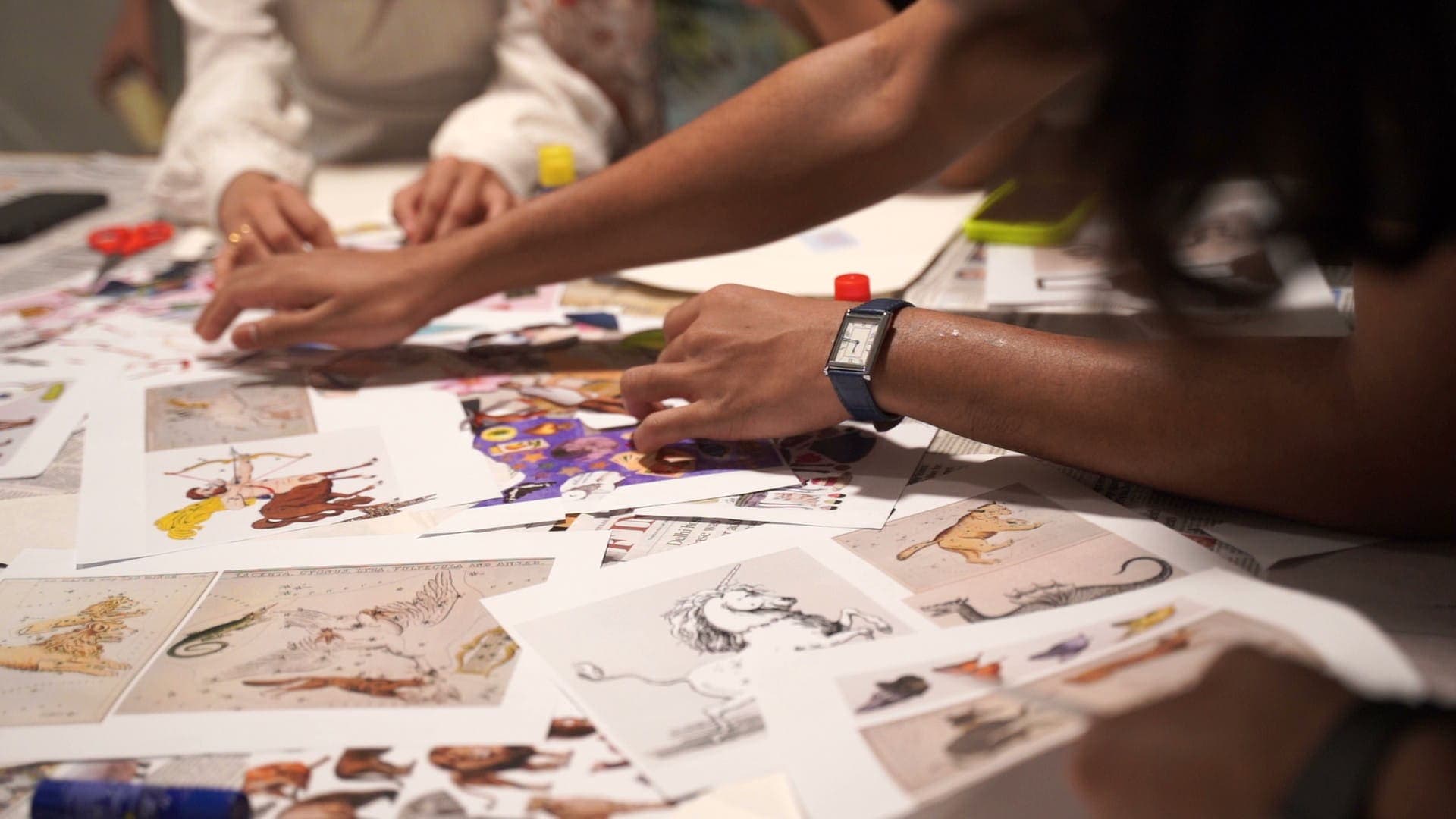 Hands cutting and pasting during a collage workshop at Rising Tide